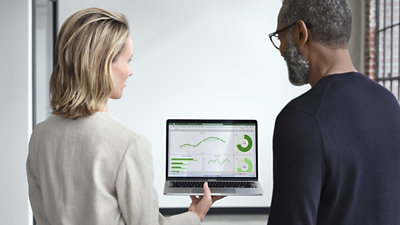 Two people looking at an Excel sheet with graphs and charts displaying data
