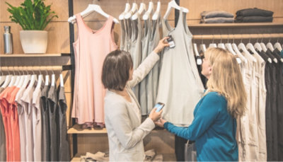 Two people looking at clothing in a retail store.