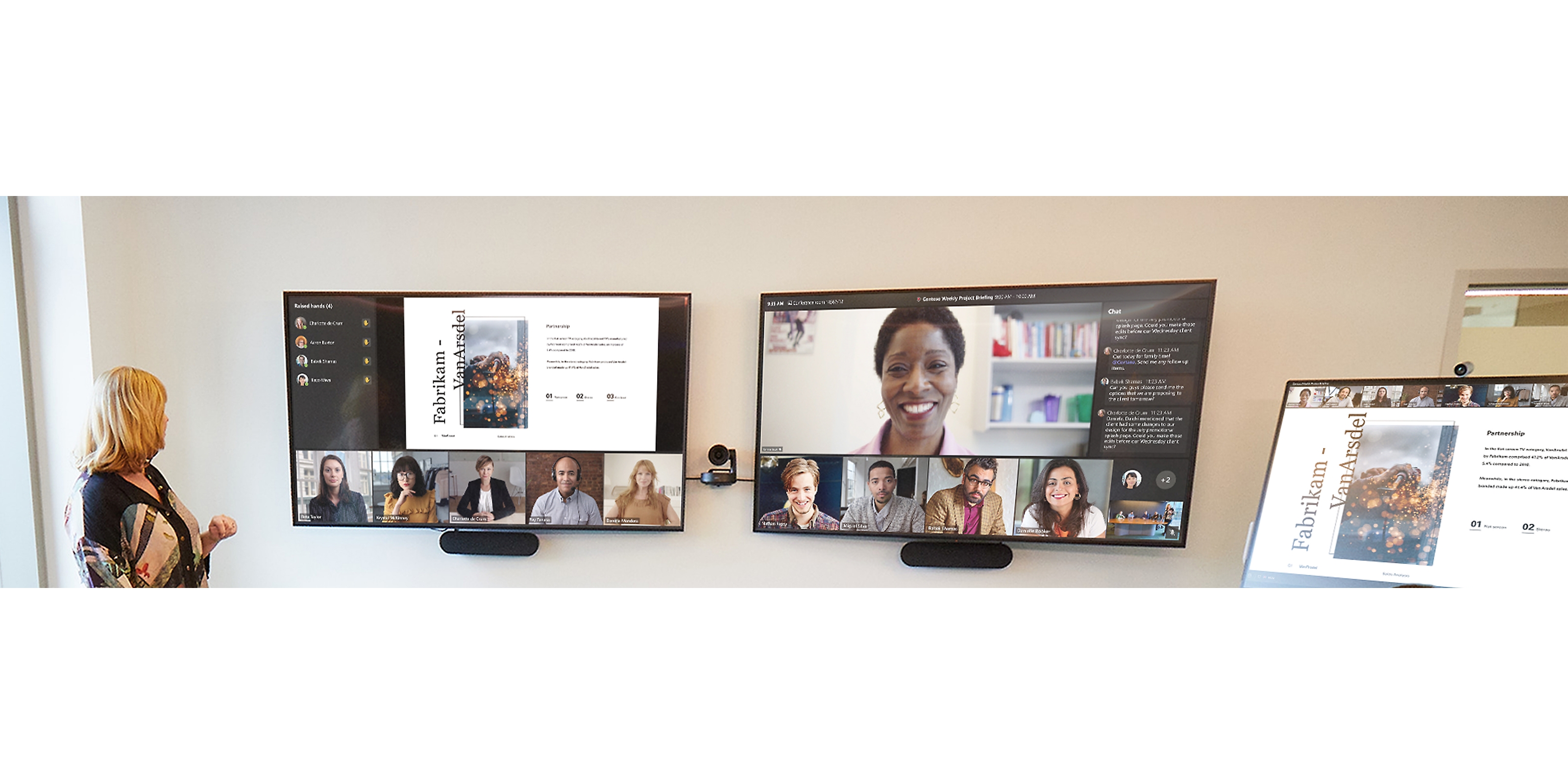A person standing in front of three screens displaying a Teams video call and a presentation being given through screen share