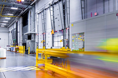 Fast-moving forklift in industrial warehouse.