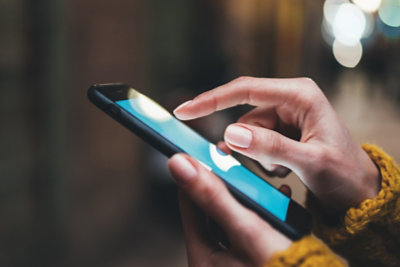 Eine Person, die den Bildschirm eines Mobiltelefons bedient