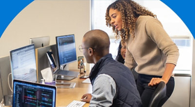 Two people working together at a desk.