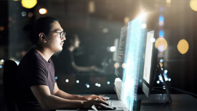 A person sitting at a desk looking at a computer screen