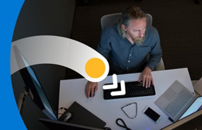 Et fugleperspektiv på en person, der arbejder ved et skrivebord og skriver på et tastatur 