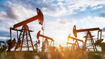 Large machines in a field that are mining for fossil fuels.