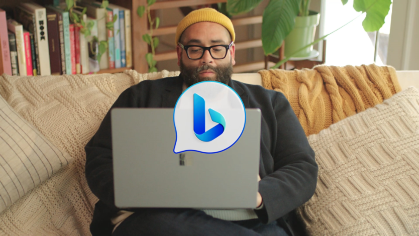 A man sitting on a couch using his laptop