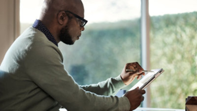 Kalem ve tablet kullanan bir kişi. 