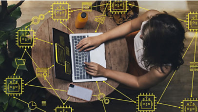 A person uses a laptop from an overhead view, surrounded by yellow AI and automation icons.