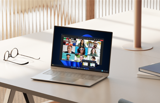Windows 11 Pro laptop on a desk with Teams share screen display