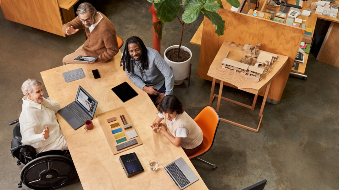 People in a conference room hold a meeting with remote participants.