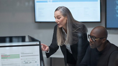 A person with long hair is giving a presentation in a room.