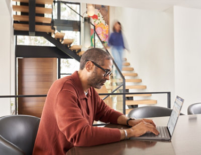 A man sitting at a desk using a laptop.