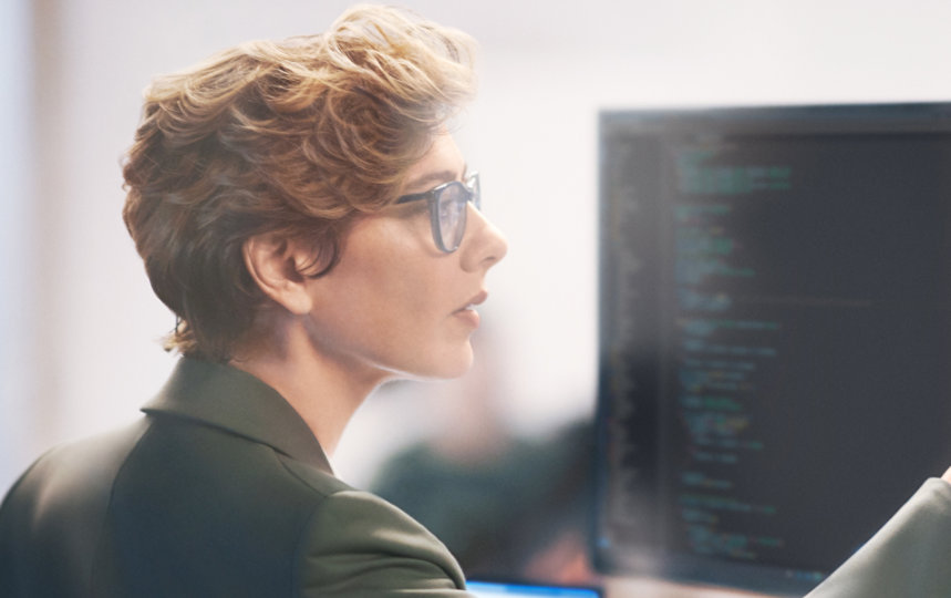 A woman professional evaluating financial data on a big screen