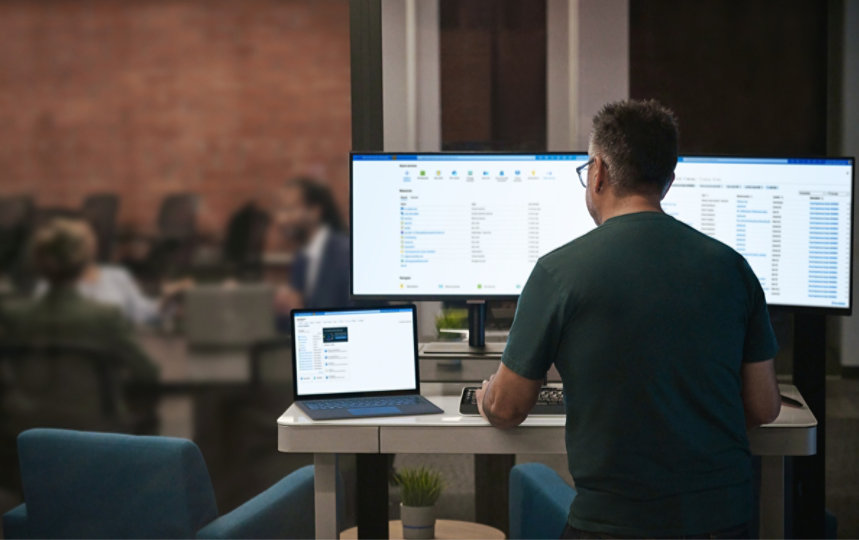 A man working with dual monitor setup and a tablet on his desk.