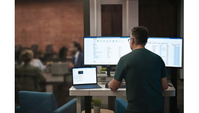 A man working with dual monitor setup and a tablet on his desk.