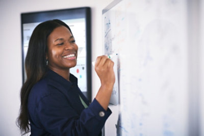 Woman drawing on a whiteboard.