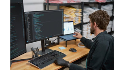 Engaged developer in focused work in the context of retail with screens showing analytics, insights powered by Azure.