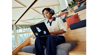 Female developer working on a laptop wearing headphones.