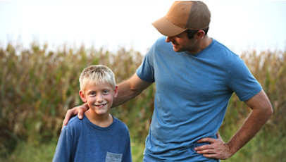 A farmer and his son in a corn field