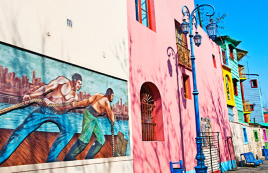 Colorful mural depicting workers pulling a rope together
