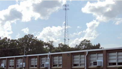 Communications tower outside of a brick building in a rural area