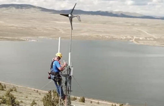 A person works on a wind turbine.