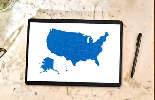 A laptop displaying a Microsoft Power BI dashboard with a map of the United States.