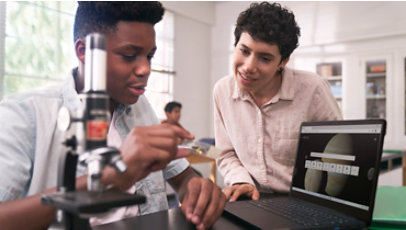 Two young students using a microscope in a science lab.