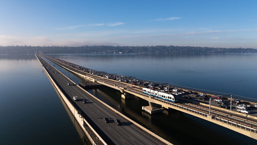 Bridge with cars and a light rail train over calm water. (Peter Bohler / Sound Transit)