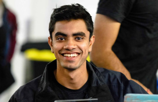 Photo of a smiling man sitting in an office environment.