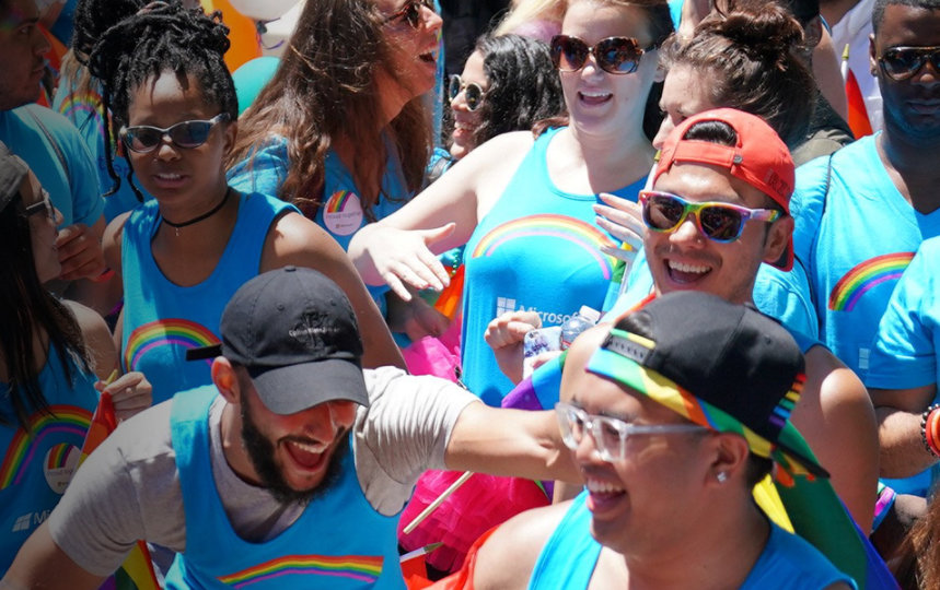 A large group of people wearing rainbow tank tops.