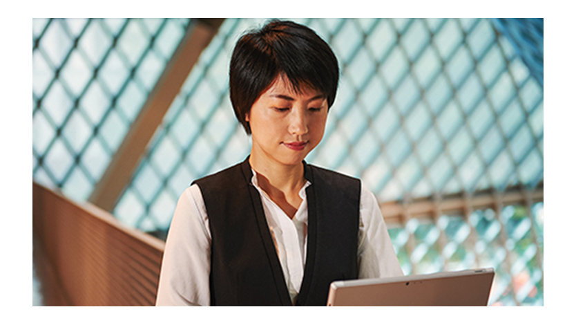 A woman looks down at her Surface device.