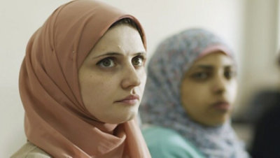 Two women wearing hijabs looking up.