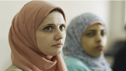 Two women wearing hijabs looking up.