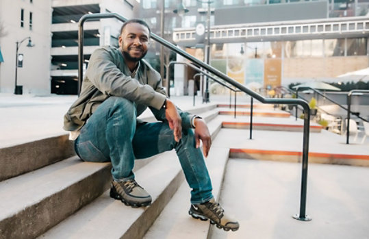 A man smiling on stairs outside of an office building