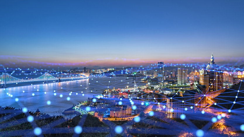 Night cityscape overlaid with glowing network nodes and connecting lines.