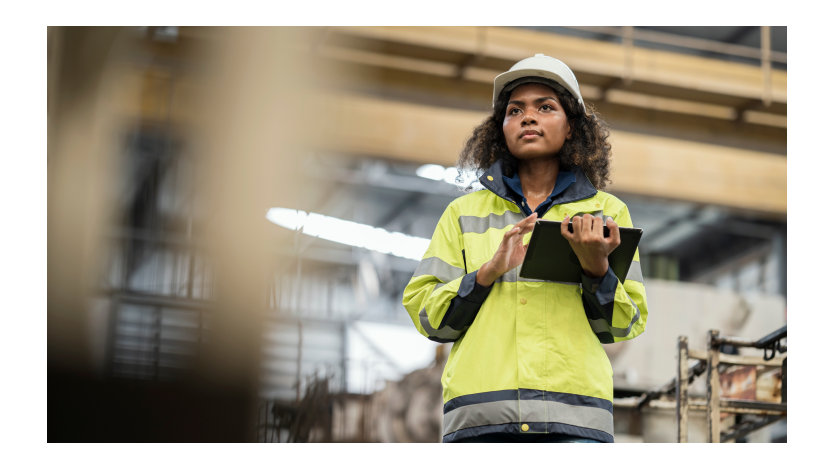 Woman wearing protective workwear using a tablet.