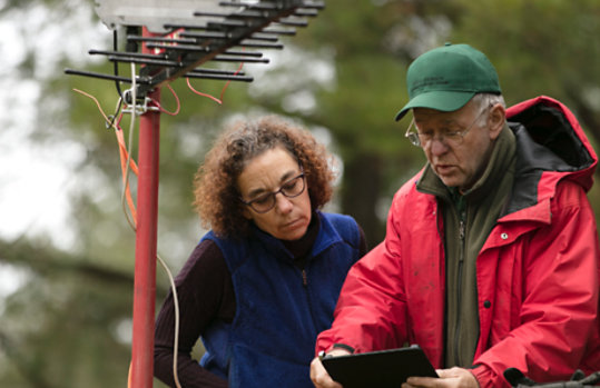 Two people reading a tablet connected to weather hardware