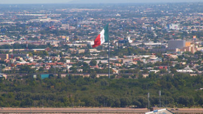 Expansive view of the City of Juarez with a Mexican flag in the foreground