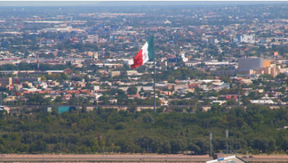 Expansive view of the City of Juarez with a Mexican flag in the foreground