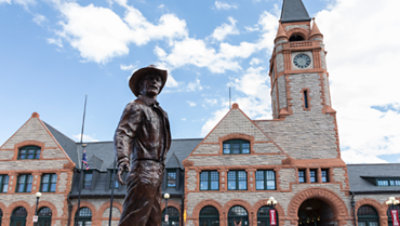 A bronze cowboy statue in front of the Cheyenne Depot Museum