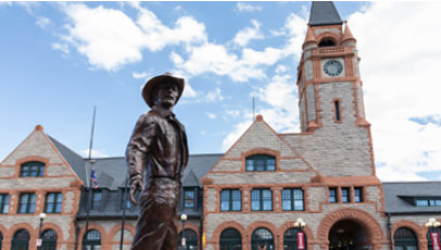 A bronze cowboy statue in front of the Cheyenne Depot Museum