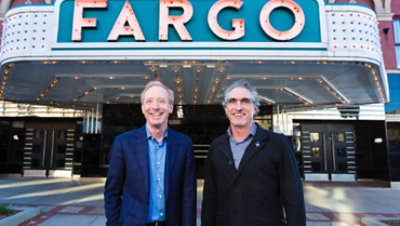 Two men stand in front of the historic art deco Fargo Theatre.