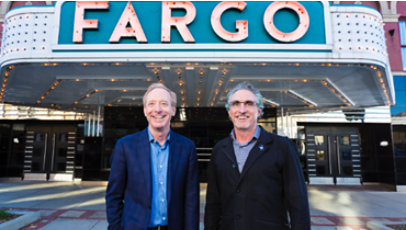 Two men stand in front of the historic art deco Fargo Theatre.