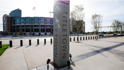 A shot of the Titletown pillar standing in front of the Green Bay Packers' own Lambeau Field.