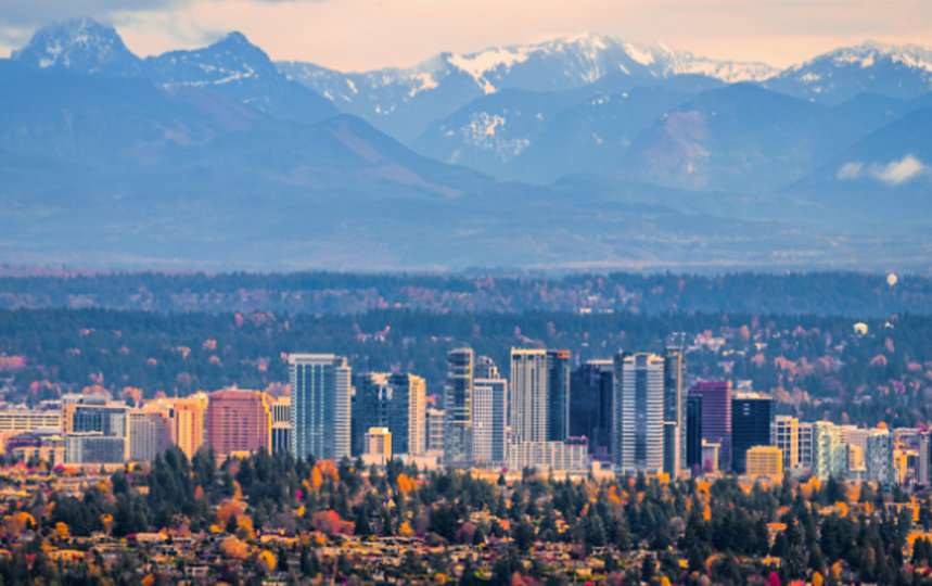 View of buildings in downtown Bellevue, Washington with mountains in the background