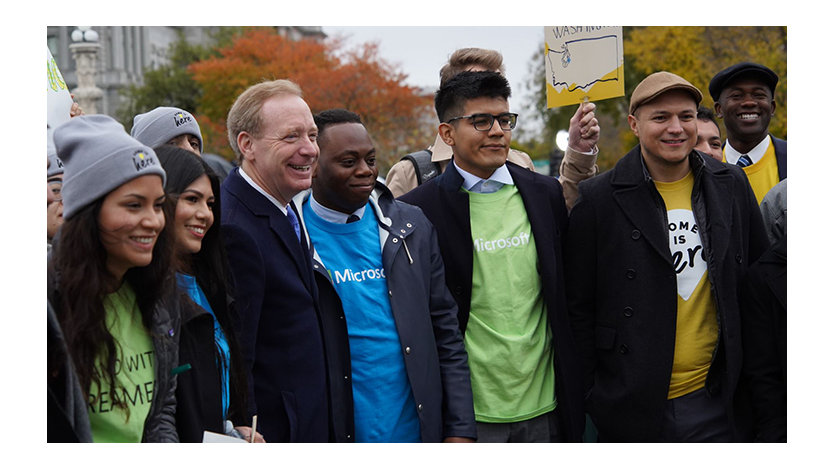 A group of young people standing outside with Microsoft president Brad Smith