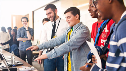 Teachers and students engaged over a laptop