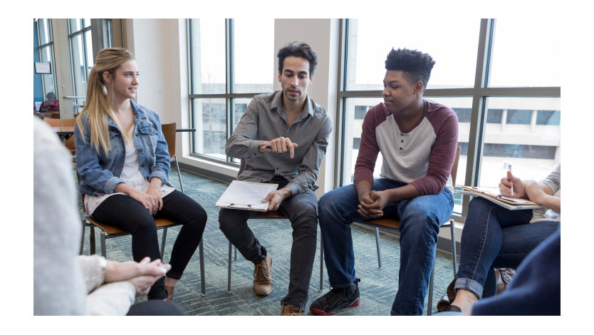Young people speak with an adult in a small group setting.