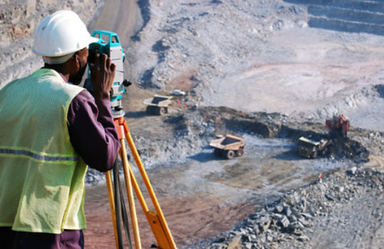 Professional engineer wearing safety gear photographing worksite.